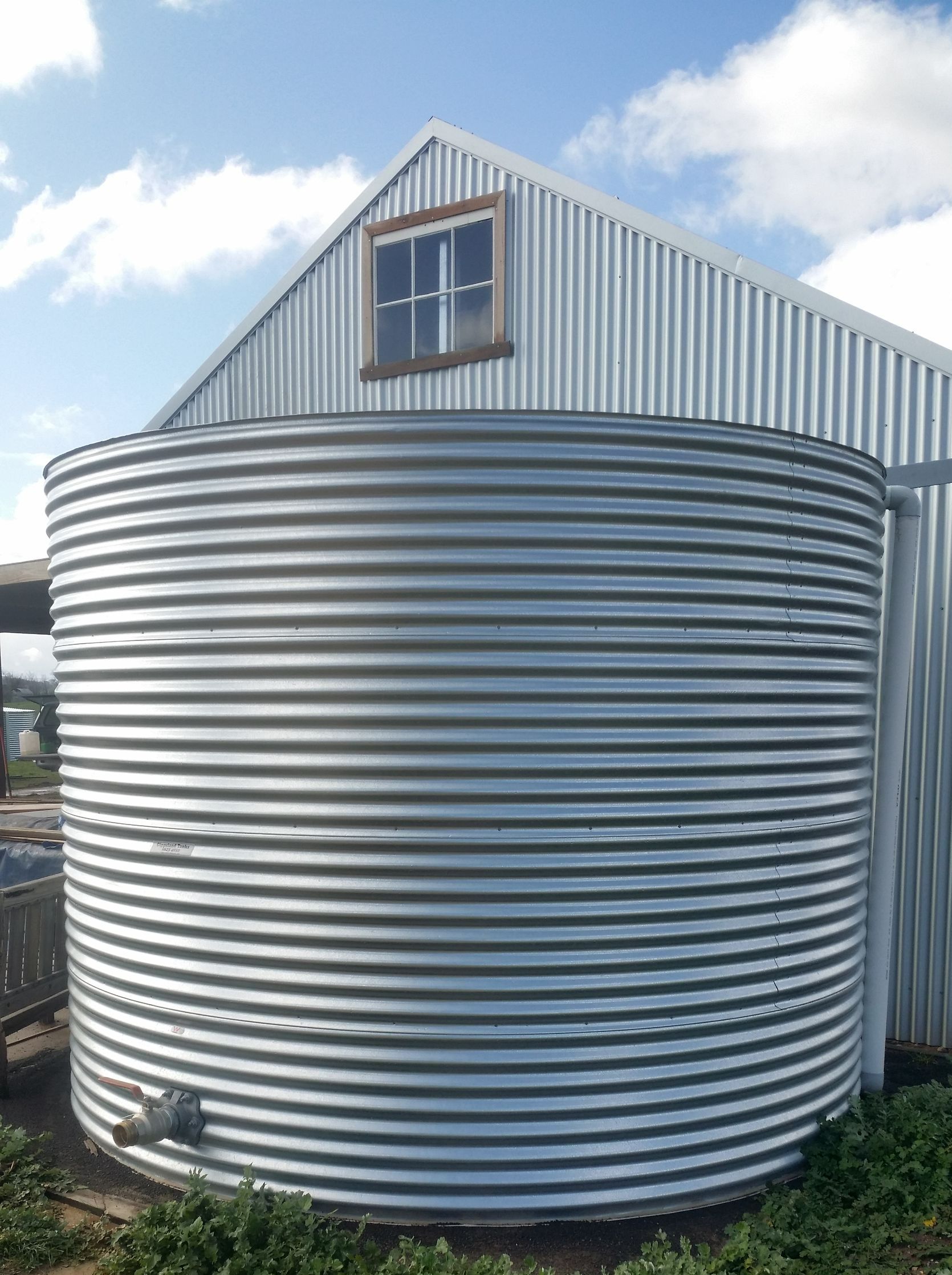 Galv steel round tank receiving from a shed